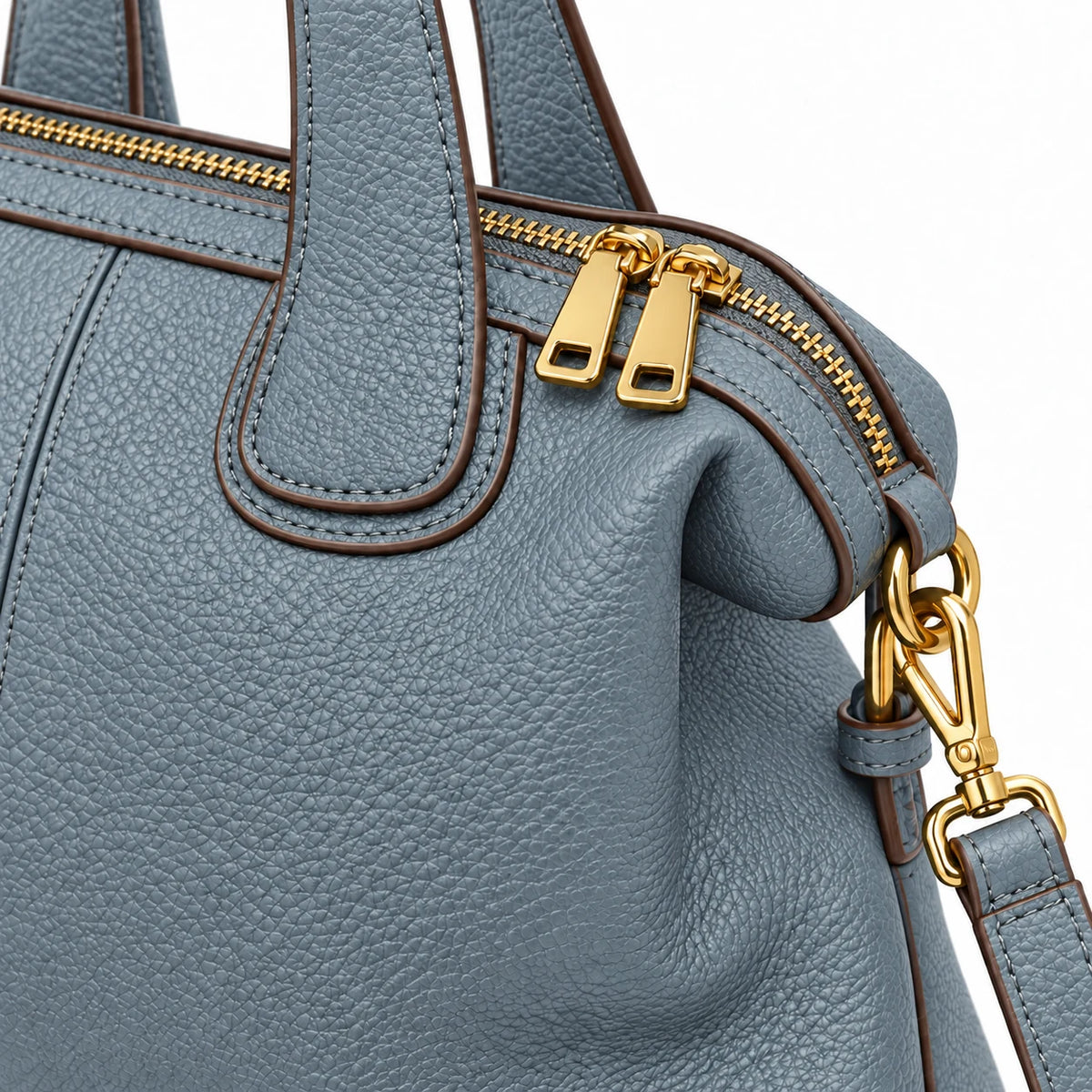 Detalhe dos zíperes e ferragens douradas da bolsa azul