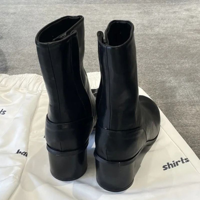 Par de Botas Tabi Coreana Feminina Preta vista superior sobre sacola de tecido branco, recorte no  calcanhar, salto grosso redondo, cabedal liso preto, apresentação estilo premium