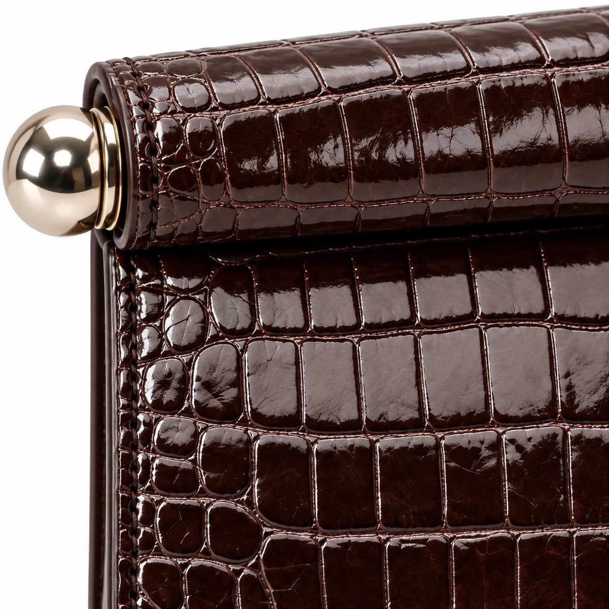 Detalhe da textura croco café da bolsa clutch Lumière