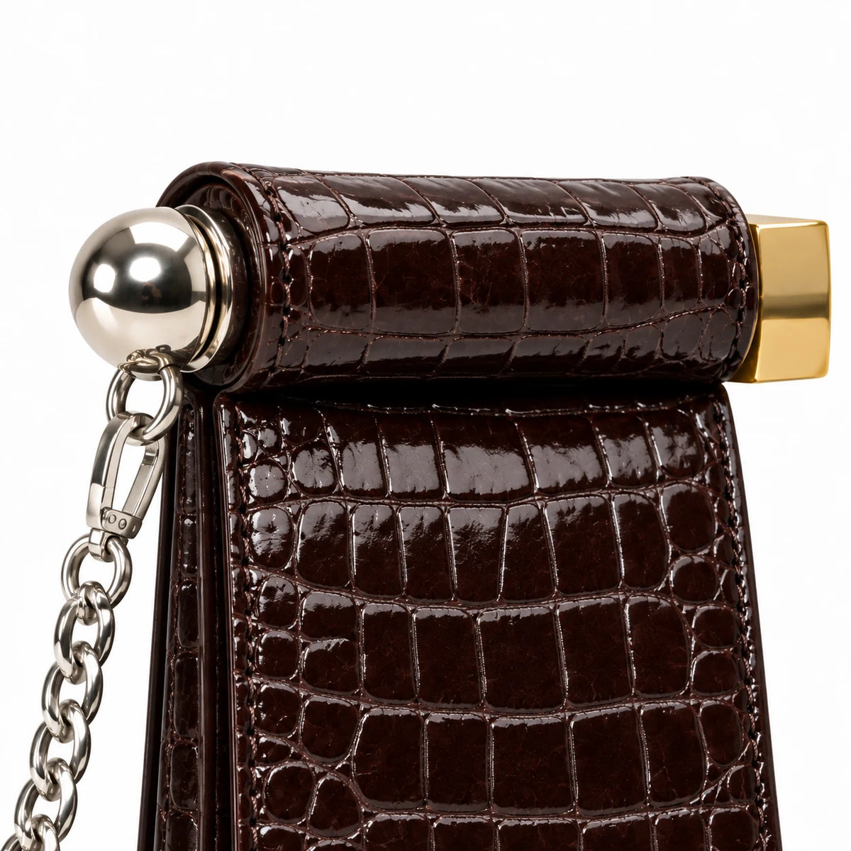 Detalhe das ferragens prateadas da bolsa clutch café croco