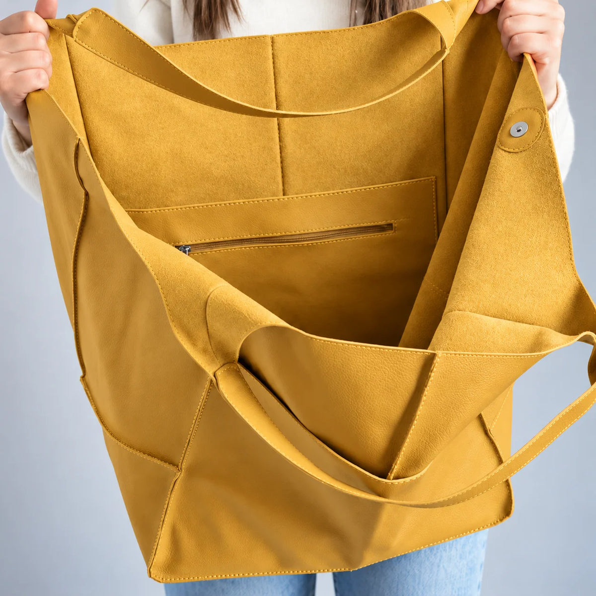 Interior da bolsa amarela Renata com bolso com zíper e botão de fechamento