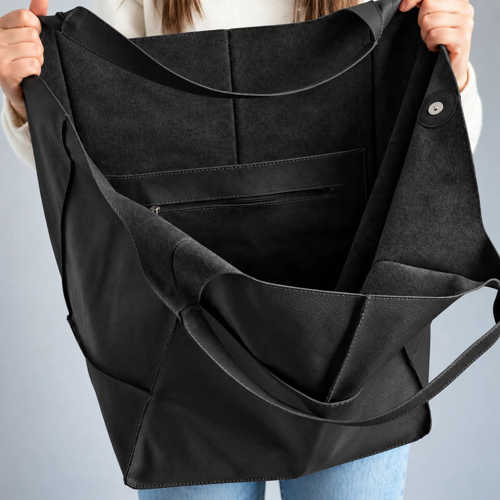 Interior da bolsa preta Renata com textura fosca, bolso com zíper e botão de fechamento