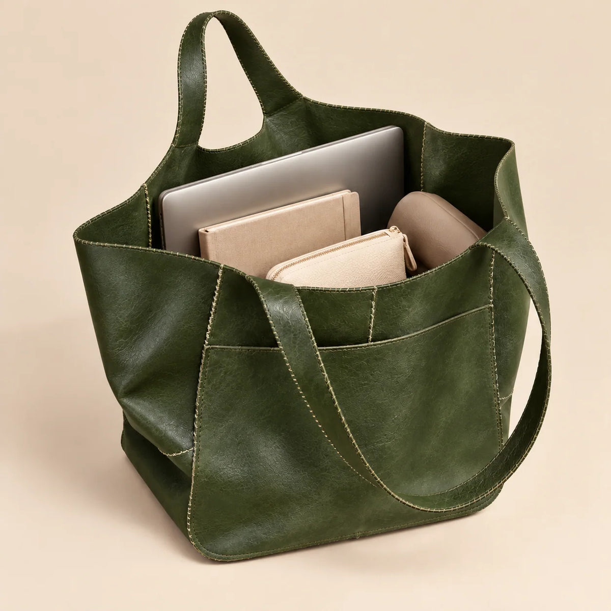 Bolsa shopper verde Renata aberta com notebook, caderno e objetos do dia a dia