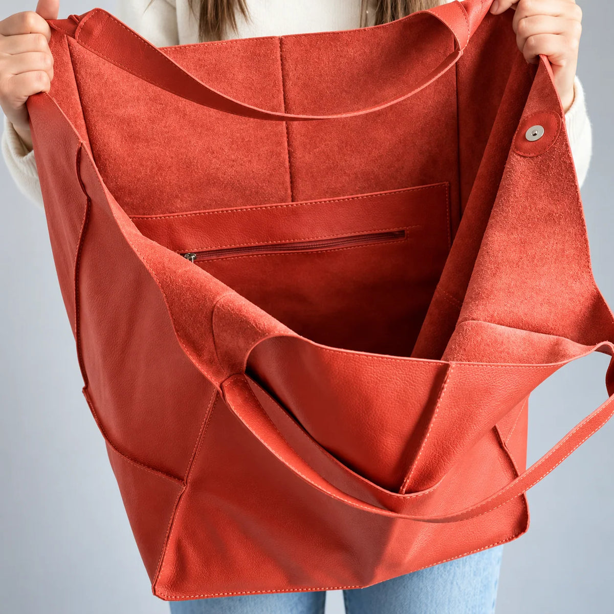 Interior da bolsa vermelha Renata com textura fosca, bolso com zíper e botão de fechamento