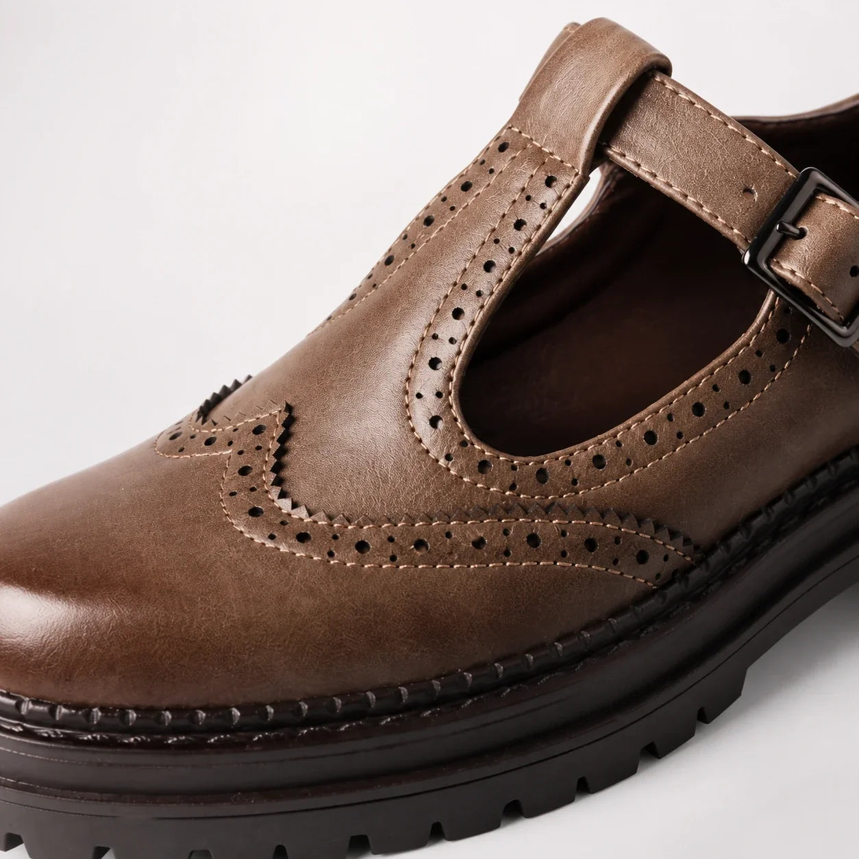 Detalhe da textura, perfurações e costuras do mocassim marrom Margot